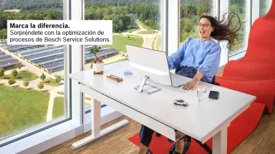 Una señora sentada en un escritorio y mira con entusiasmo la pantalla frente a ella con los ojos muy abiertos. Parece como si hubiera sido lanzada hacia atrás, su cabello ondea y está agarrada al escritorio.