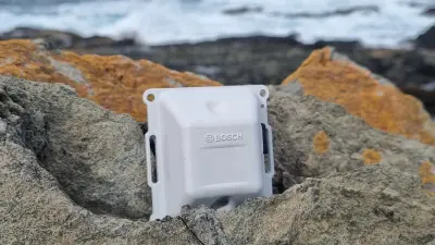 The asset tracking device lies on various stones.