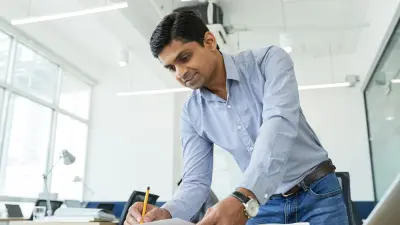  Employee at a desk writes a note