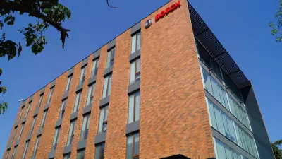 View of the Bosch building in Santiago de Chile, it has a red brick wall, the Bosch logo can be seen at the top of the building.