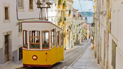 A tram drives through a street of Lisbon