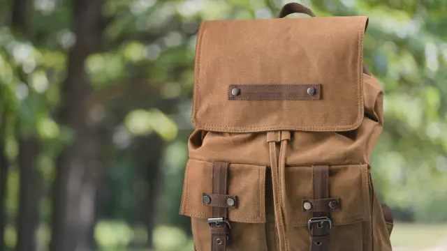 A brown backpack on a bench