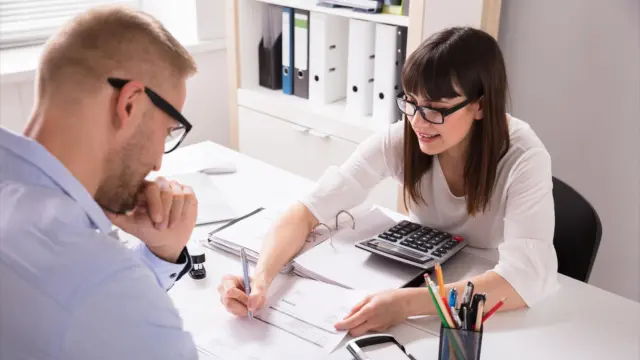 A young employee explains a statistic to a colleague