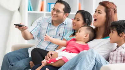 A couple with a baby look smiling at the camera