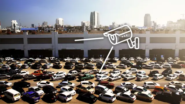 Ein Parkplatz mit einem Haus im Hintergrund inkl. Zeichnung aus Überwachungskamera.