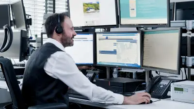 Employee in the monitoring center looks at the screens