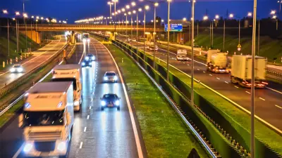 View of a motorway at night, many vehicles can be seen with their lights on