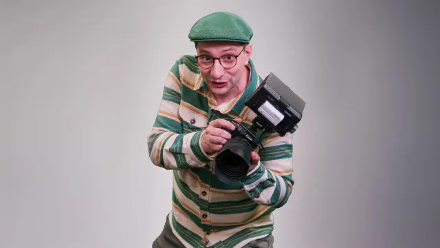 Steffen lächelt und zeigt mit seinem Zeigefinger in die Kamera.