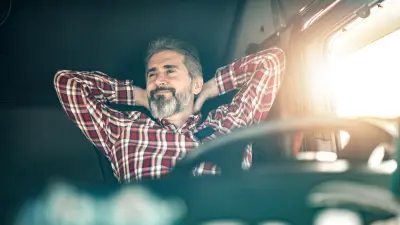Un conductor sentado tranquilamente frente al volante de su camión