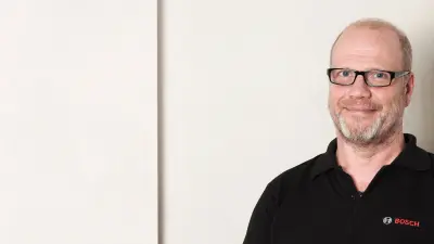 Detlef is in front of a wall. Portrait.