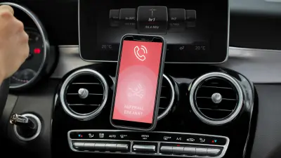 Vista de un smartphone en la consola central de un vehículo, con la pantalla del teléfono en la que se muestra que se ha activado un eCall para obtener una rápida asistencia en carretera. 