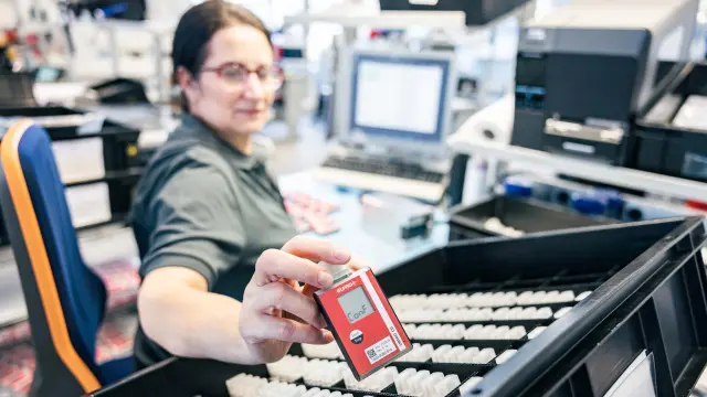 A woman puts an Elpro data logger into a shipping crate for medication.